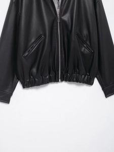Detailed view of black PU leather jacket with metal zipper and elastic ribbed hemline