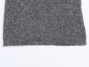 Nahaufnahme eines dunkelgrauen ärmellosen Strickpullovers mit flauschiger Wolltextur