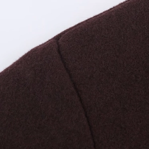 Detailed macro view of dark brownish red woolen fabric texture and stitching on the coat