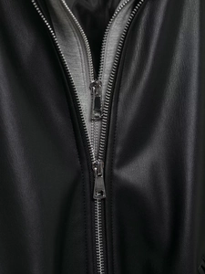 Detail of premium black faux leather texture with silver dual-ended metal zipper