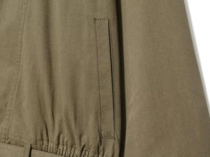 Dettaglio della trama in twill kaki e della vita elastica sul trench da donna
