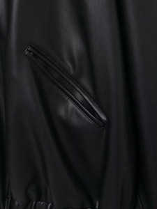 Detailed view of black PU leather jacket featuring side pockets and elastic hem stitching