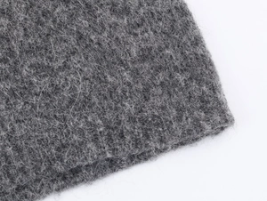 Nahaufnahme von dunkelgrauem Strickstoff mit warmen Wollfasern und feiner Textur