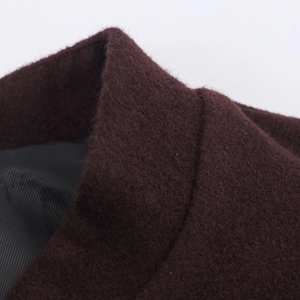 Macro view of burgundy wool coat showing stand collar sewing and black lining texture
