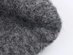 Makroaufnahme von dunkelgrauem Strickpullover zeigt flauschige Mohair-Wollstruktur