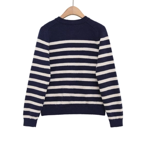 Detail showing the ribbed round neckline and navy white striped texture of the knit sweater