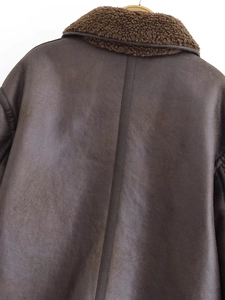 Détail d'une veste en similicuir marron foncé avec col en laine d'agneau et couture au dos
