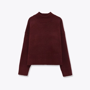 Detailed view of the dark wine red knit sweater showing thick texture and ribbed cuffs