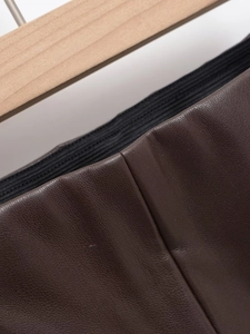 Gros plan détaillé du pantalon en cuir marron avec taille élastique et coutures précises