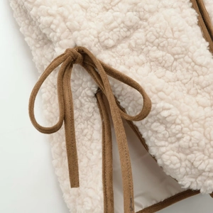 Faux shearling vest with adjustable side ties and brown suede contrast trim details