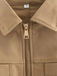 Detail of khaki twill jacket collar with premium gold metal zipper and size S label