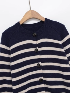 Detailed close-up of navy and white striped knit cardigan with dark round buttons