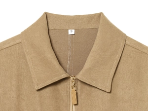 Close-up of khaki twill jacket collar with premium metal zipper and leather puller