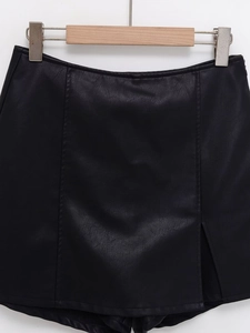 Detail shot of black PU leather skort showing front slit and fine stitching texture