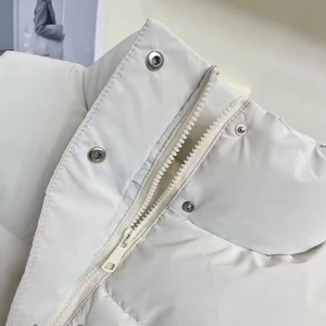 Detail of stand-up collar with metallic snap button and resin zipper on PU leather vest