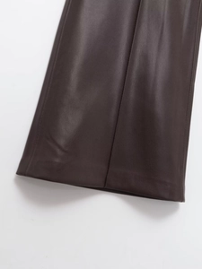 Détail du pantalon en similicuir marron foncé montrant la texture fine et la couture