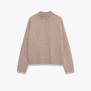 Macro detail of high-quality oatmeal knit fabric with ribbed mock neck and texture