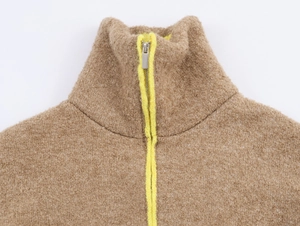 Vue macro de la veste en polaire kaki avec bordure jaune et détail de fermeture éclair