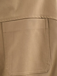 Detailed macro view of khaki twill cotton fabric with precise topstitching on the pocket