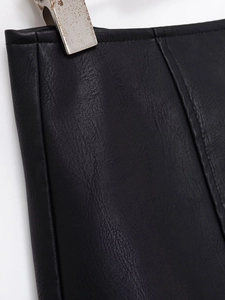 Macro detail of black PU leather fabric showing fine grain texture and vertical stitching