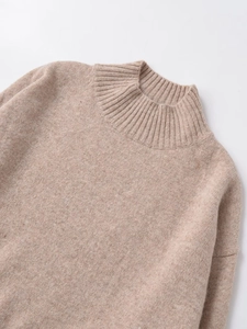 Close-up detail of high-density knit fabric and turtle neck collar in oatmeal color