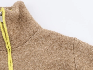Détail de la veste en polaire camel avec col montant et fermeture éclair jaune fluo
