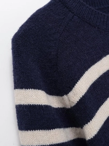 Detailed close-up of blue and white striped knit sweater neckline and shoulder texture