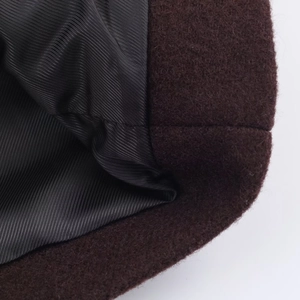 Close-up of the smooth black twill lining and premium brown wool texture of the winter coat