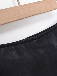 Detailed close-up of high-quality black faux leather fabric texture and stitching on hanger