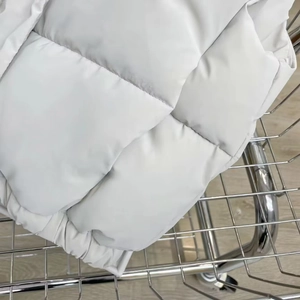 Detail view of white PU leather quilted vest showing horizontal stitching and matte fabric