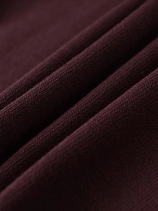 Macro detail of high-quality burgundy knit fabric showing fine needlework and soft texture