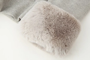 Détail de la manche d'un manteau en laine gris avec garniture en fausse fourrure chic