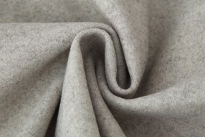 Gros plan sur un tissu en laine gris clair épais avec texture brossée et plis doux