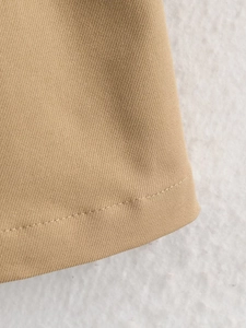 Detailed close-up of high-density khaki twill fabric texture and precise hem stitching