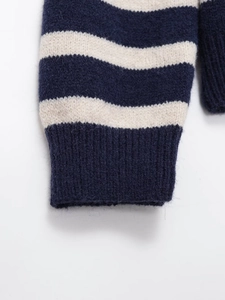 Detail of navy and cream striped knit sweater cuff with soft wool blend texture