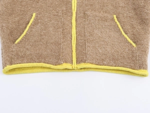 Détail de l'ourlet de veste polaire marron avec bordure jaune et poches latérales