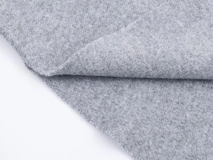 Detailed close-up of soft grey knit fabric with refined wool blend texture and weave