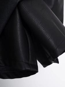 Detail shot of black PU leather skirt stitching and high-quality textured surface