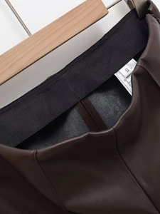 Détail de la large taille élastique et étiquette de lavage du pantalon en cuir PU brun