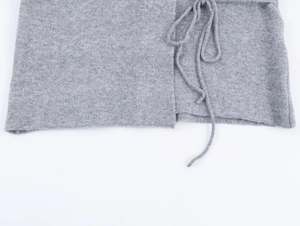 Detail view of gray long sleeve knit cardigan showing fine texture and side tie design