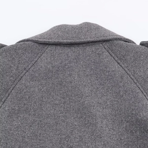 Detailed view of the raglan sleeve seams and gray wool-like fabric texture on the coat
