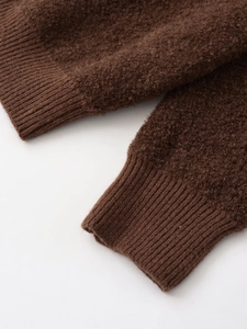 Detail of ribbed cuffs on brown teddy fleece jacket with thick knit texture