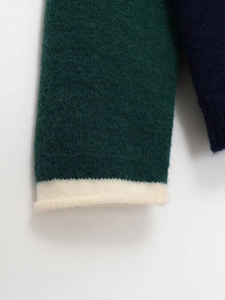 Gros plan sur le poignet d'un pull en maille avec bloc de couleur et bordure roulée
