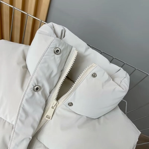 Close-up of stand-up collar with metallic snap buttons and zipper on quilted PU vest