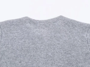 Detailed close-up of grey knit texture and round neckline of long sleeve cardigan