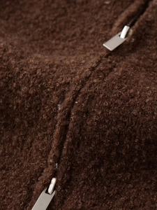 Detailed macro view of the brown fuzzy fleece fabric and high-quality silver metal zipper