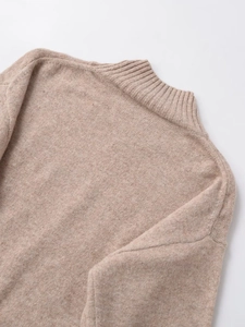 Detailed close-up of ribbed mock neck and soft oatmeal knit texture on the sweater