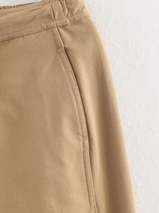 Detail of khaki twill fabric pants featuring side pockets and fine double-needle stitching