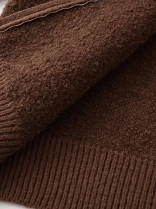 Close-up of the textured brown knit cardigan with ribbed cuffs and fuzzy wool fabric