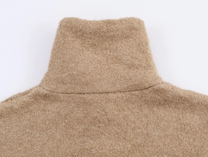 Détail du col montant en maille bouclée camel avec coutures soignées et texture douce